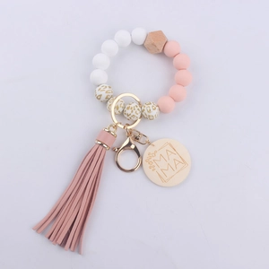 Close-up of silicone beads, pink tassel, and wooden MAMA tag on the wristlet keychain