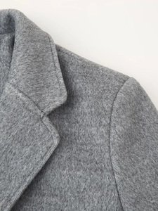 Close-up of gray wool coat detailing the lapel collar and soft textured fabric surface