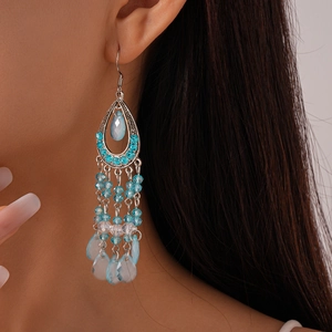 Close-up of bohemian blue teardrop tassel earrings with crystal beads on a model