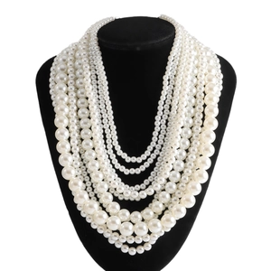 Elegant multi-layered faux pearl necklace featuring graduated bead sizes on a black bust