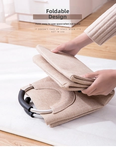 Detail of foldable laundry basket with metal handles collapsed for compact storage