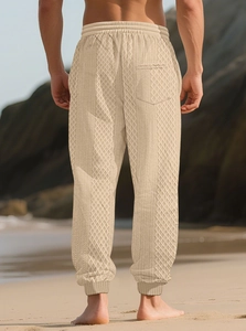 Détail de pantalon de jogging beige pour hommes avec texture losange et ourlet aux chevilles