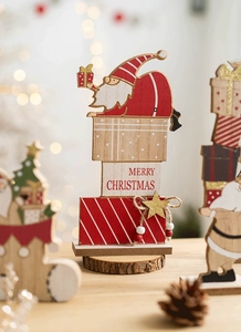 Detail of wooden Merry Christmas table decor with Santa Claus and gift box motifs
