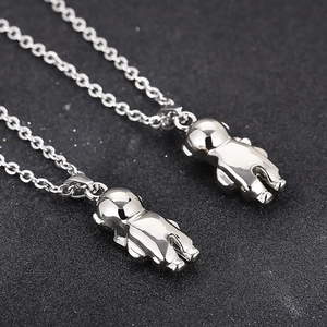Silver astronaut pendant necklace in stainless steel for men and women on dark background