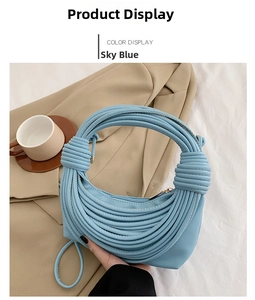 Detail of sky blue crescent underarm bag with unique knotted tubular handle and gold zipper
