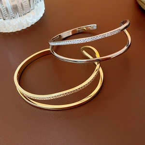 Macro shot of gold and silver open bracelets with double-layer zircon pave inlays