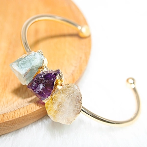 Macro detail of natural amethyst and citrine stones on a gold plated adjustable bracelet