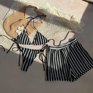 Three-piece black and white striped bikini set with halter top and textured shorts