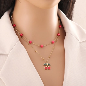 Chic collier double épaisseur en acier inoxydable avec pendentif cerise rouge sur mannequin