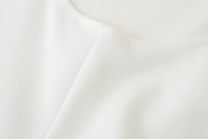 Détail de la texture lisse du tissu blanc et de la couture soignée de l'encolure