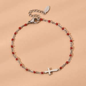 Detail of silver stainless steel cross bracelet with vibrant red enamel round beads