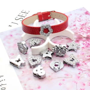 Detail of red crocodile pattern leather bracelet with silver rhinestone slide charms