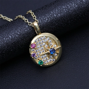 Gold starburst medallion necklace with blue center stone and multicolor crystals
