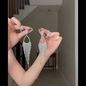 Detailed view of silver tassel drop earrings with sparkling rhinestones for women