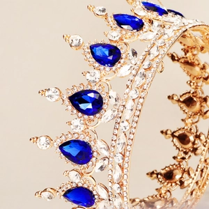 Close-up of golden bridal crown with blue teardrop gems and sparkling rhinestones