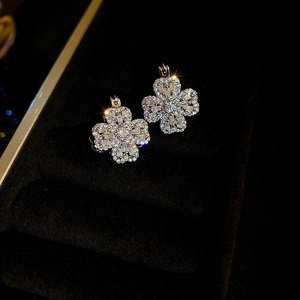 Close-up of sparkling zircon clover earrings in a black velvet jewelry box gift setting