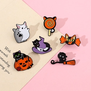 Detail view of 6 Halloween enamel pins featuring cats, pumpkins, and magic hats on pink paper