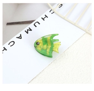 Detailed macro view of tropical fish hair clip in yellow and green striped acetate
