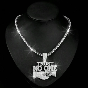 Detail of silver TRUST NO ONE hip hop pendant with rhinestones on Cuban link chain