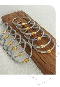 Macro view of twisted cable bangles with faceted colorful zircon stones on wood
