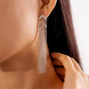 Close-up of silver tassel earrings with geometric chevron design on model's ear