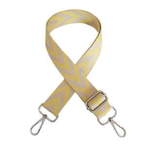 Close-up of yellow and beige herringbone woven strap with silver swivel metal hooks
