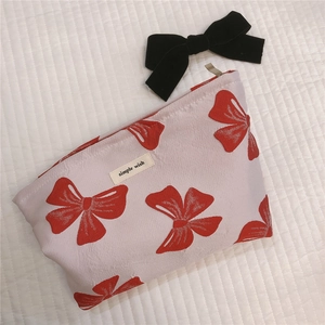 Detail of canvas makeup bag with red bow pattern and Simple Wish fabric label