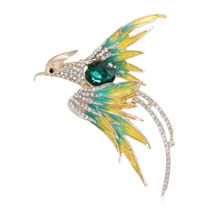 Elegant phoenix brooch with gold plating, green enamel wings and emerald crystal center