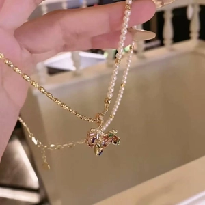 Vue détaillée d'un collier cheval doré à deux rangs avec perles et pendentif coloré
