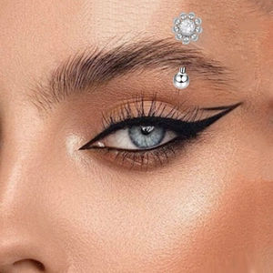Macro detail of G23 titanium eyebrow ring with silver daisy zircon and ball end