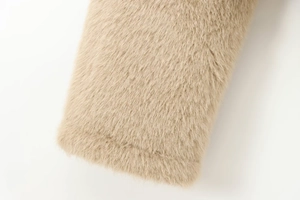 Close-up of high-density beige faux fur texture showing soft and smooth synthetic fibers