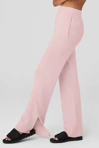 Vista dettagliata dei pantaloni yoga a coste rosa chiaro con eleganti spacchi laterali sul fondo