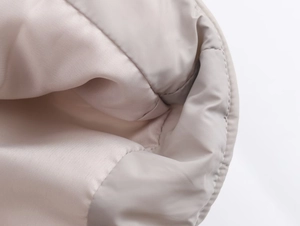 Close-up of the beige waterproof jacket sleeve showing precise quilting and fabric texture