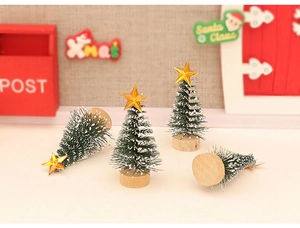 Set of four mini green Christmas trees with wood bases in a festive miniature scene