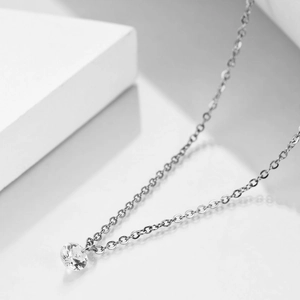 Detailed view of minimalist silver necklace with a single round clear zircon pendant