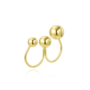 Detailed view of dual-layer gold ring with three varying spheres and polished finish