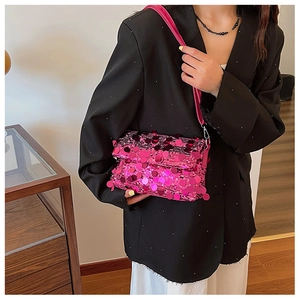 Detailed view of fuchsia sequin crossbody bag with metallic accents and chain strap