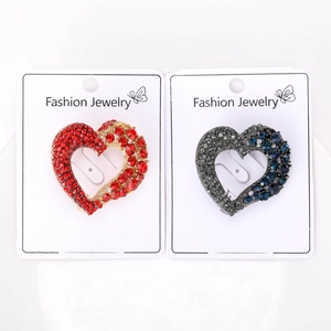 Detailed view of heart-shaped rhinestone brooches in red and blue on display cards
