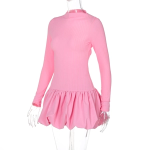 Détail de la robe rose à manches longues montrant la maille côtelée et l'ourlet bouffant
