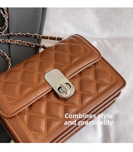 Close-up of brown quilted bag with silver metal twist lock and layered side gussets