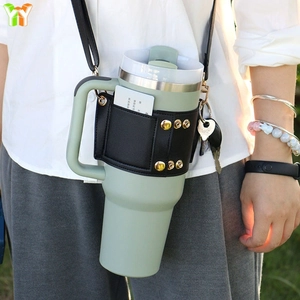 Outdoor lifestyle shot of a black leather cup sleeve with adjustable shoulder strap and card slot