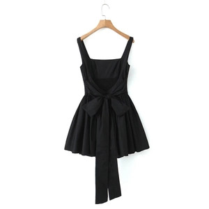 Detailed back view of a black mini dress featuring a large decorative bow and waist tie