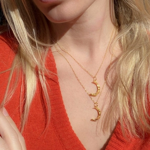 Detailed view of layered gold moon pendants with textured finish on a twisted chain