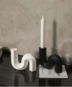 Detail of S-shaped wave ceramic candle holder with matte vertical stripe texture
