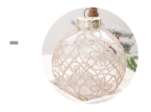 Detailed view of an 8cm transparent Christmas ball with golden glitter floral patterns