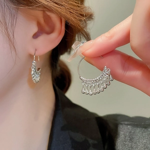 Silver metallic C-shape drop fringe earrings with waterdrop charms shown on model