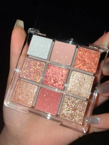 Close-up of a 9-color eyeshadow palette with matte and shimmer shades in acrylic case