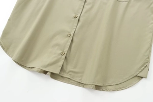 Detail view of olive green poplin shirt showing button placket and curved hemline