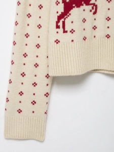 Detail of Christmas reindeer jacquard knit sweater with ribbed cuffs and hem