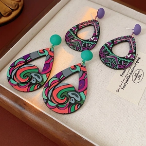 Boucles d'oreilles bohèmes en forme de goutte aux motifs colorés sur plateau en lin
